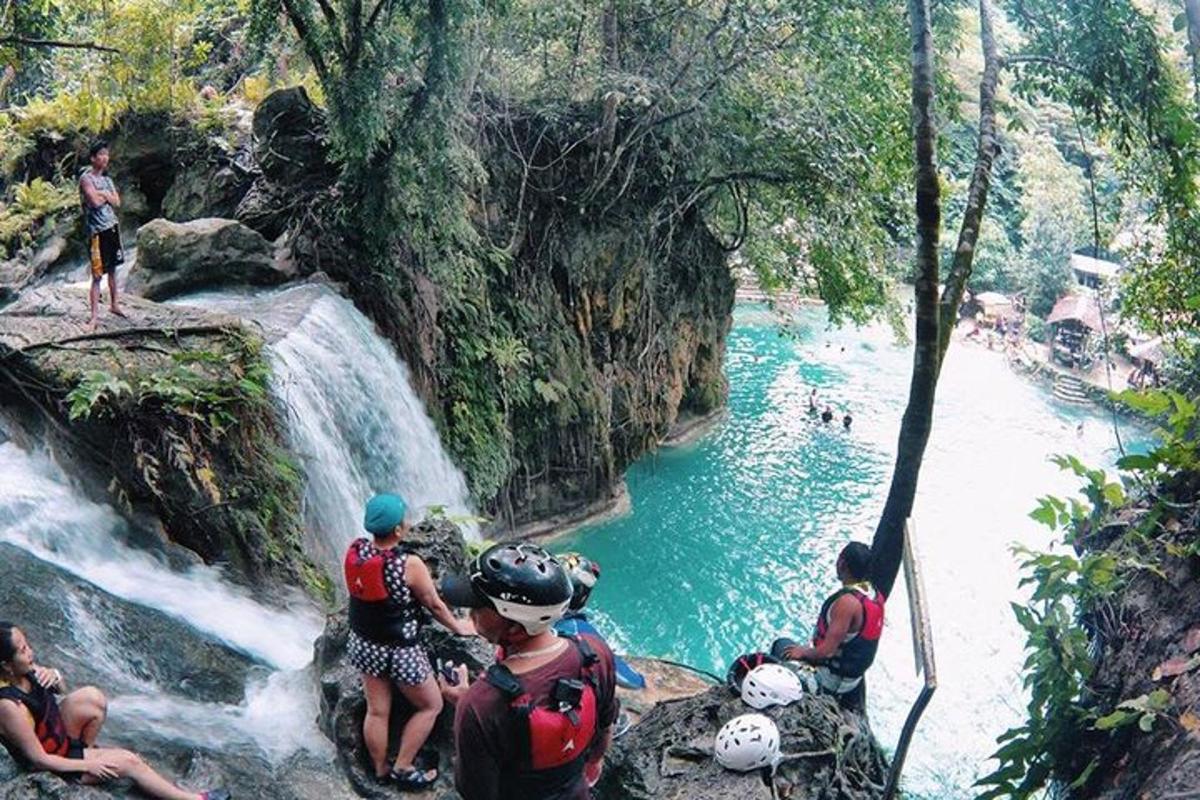 a group of people standing at the edge of a waterfall