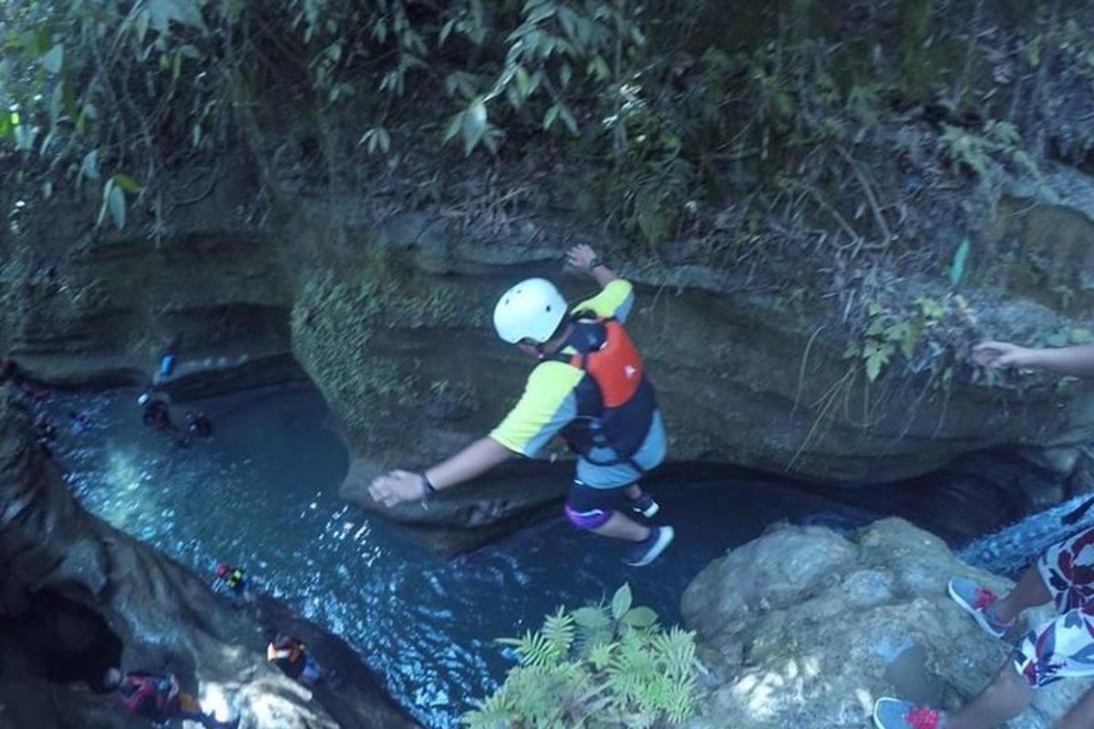 un hombre parado sobre una roca en un río