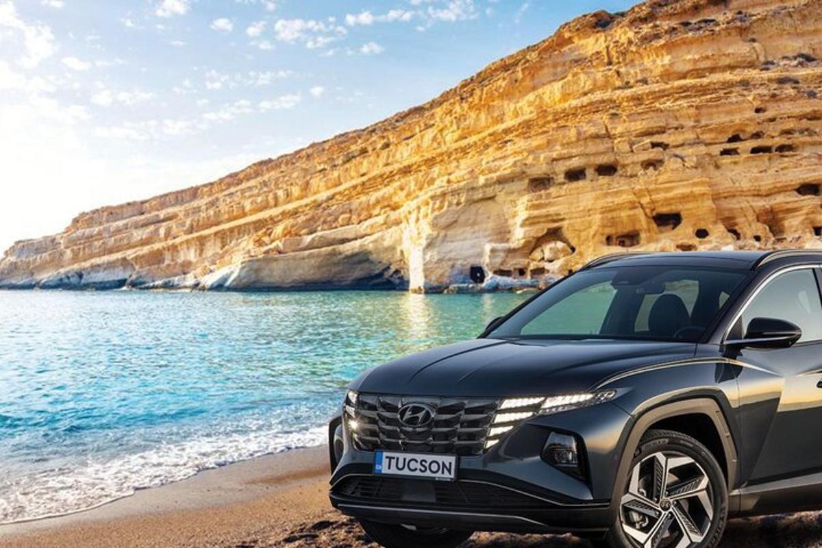 a black suv parked on a beach next to the ocean