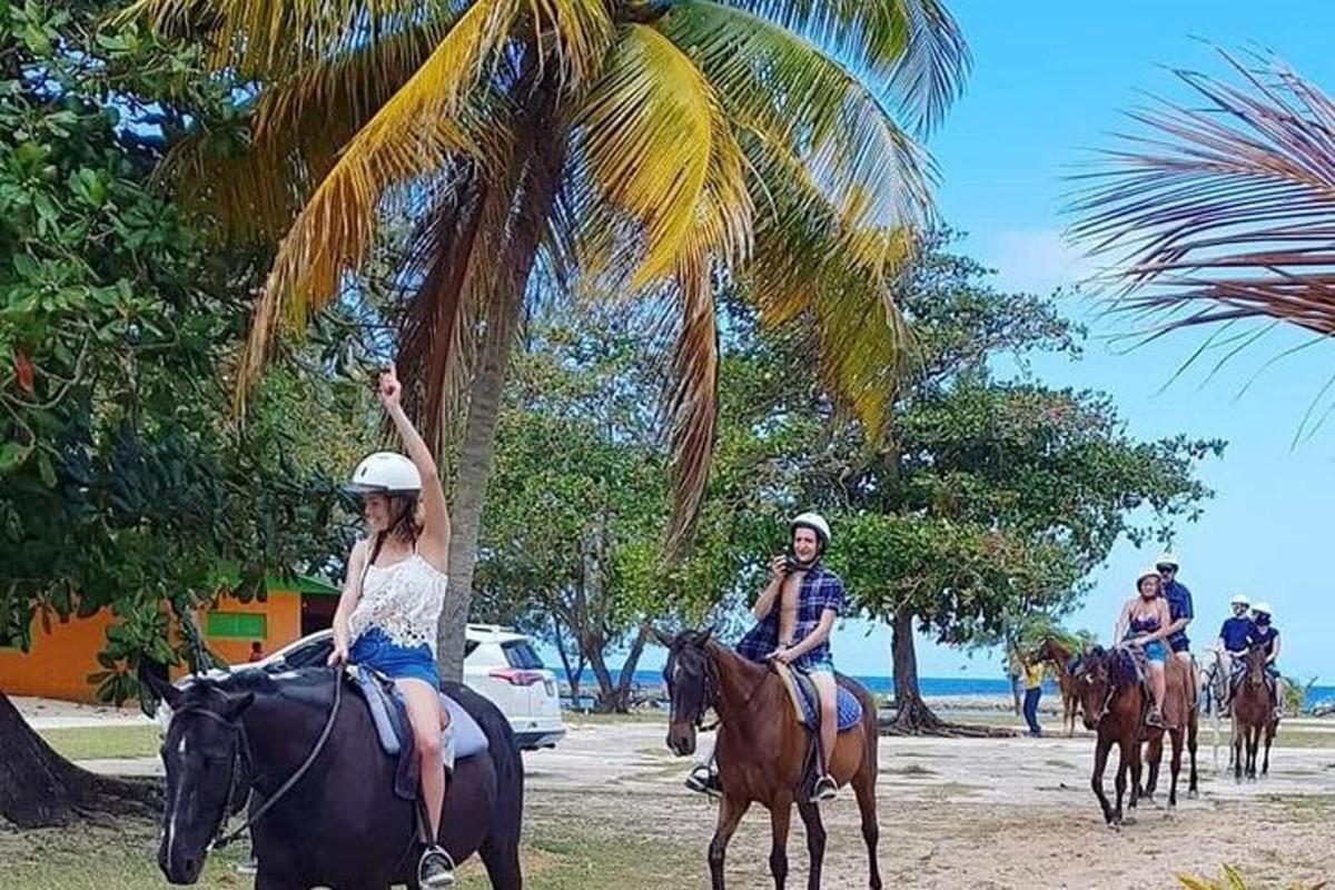 a group of people riding horses on the beach