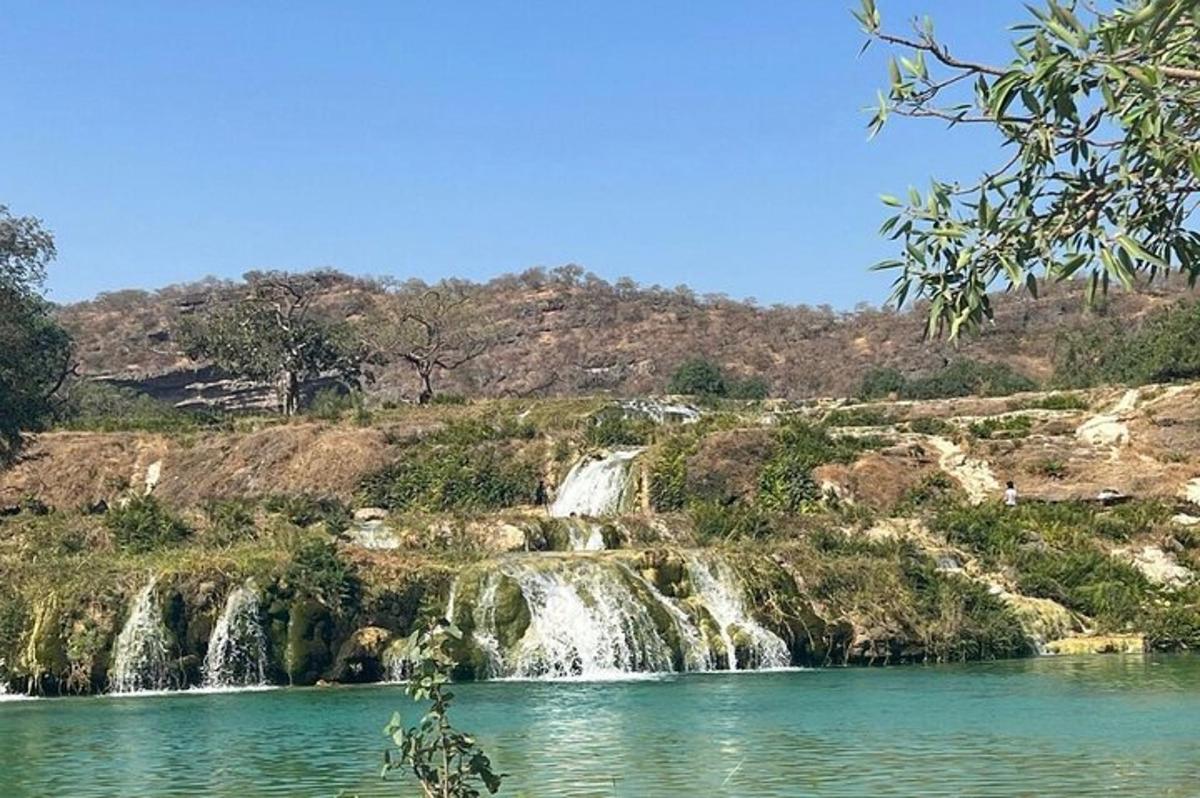 una cascata su una collina accanto a uno specchio d'acqua