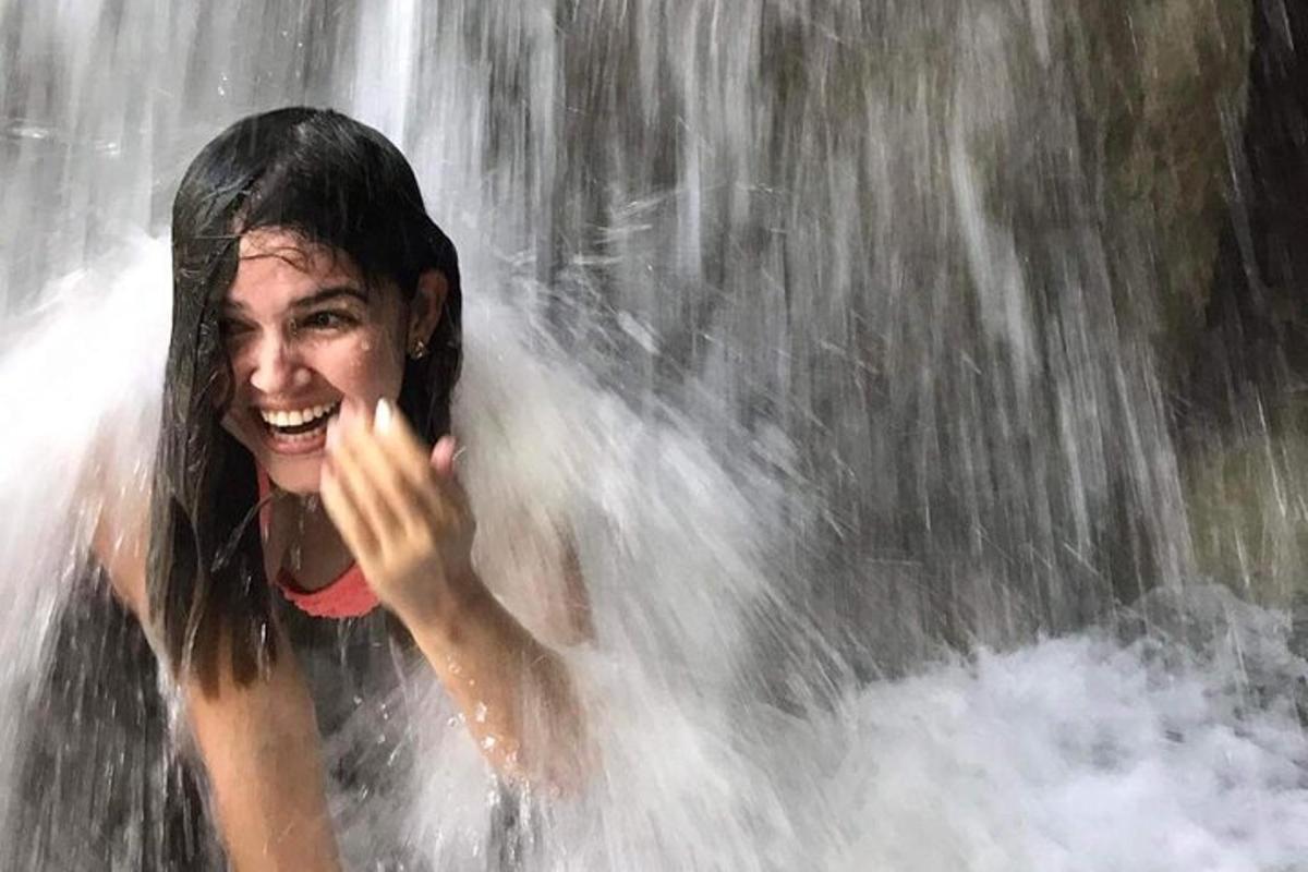 žena stojaca pred vodopádom