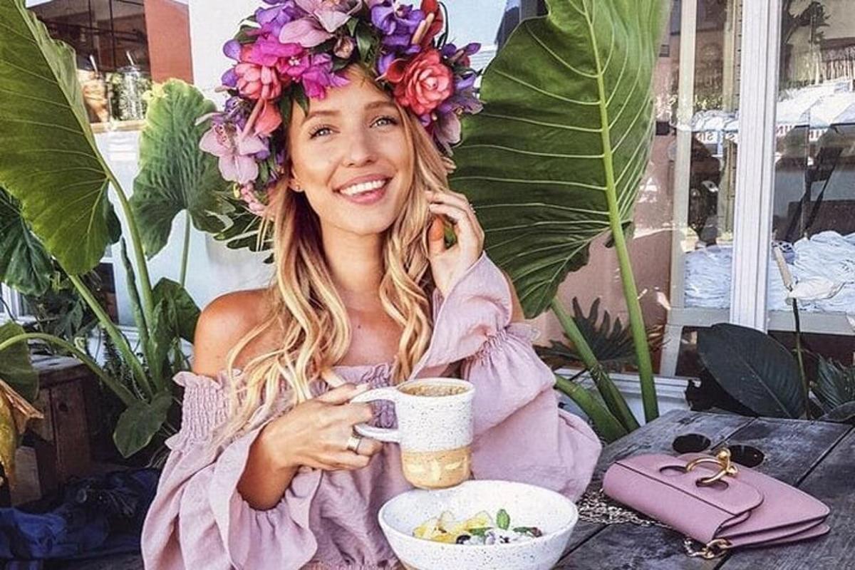 una mujer sentada en una mesa con una taza de café