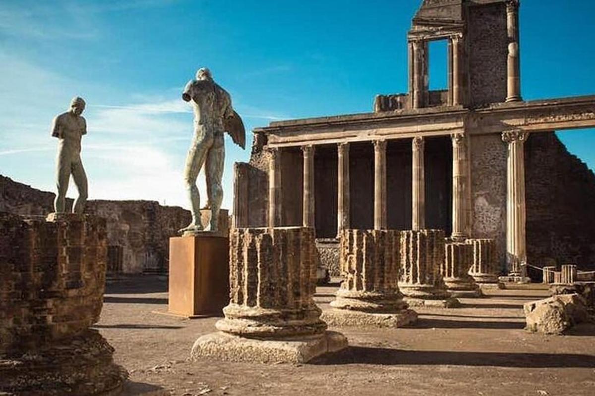 ένα άγαλμα ενός άνδρα σε ένα βάθρο μπροστά από ένα κτίριο
