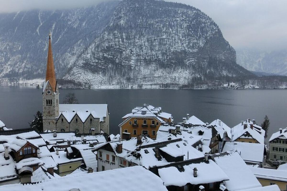 uma cidade coberta de neve com uma igreja e uma montanha