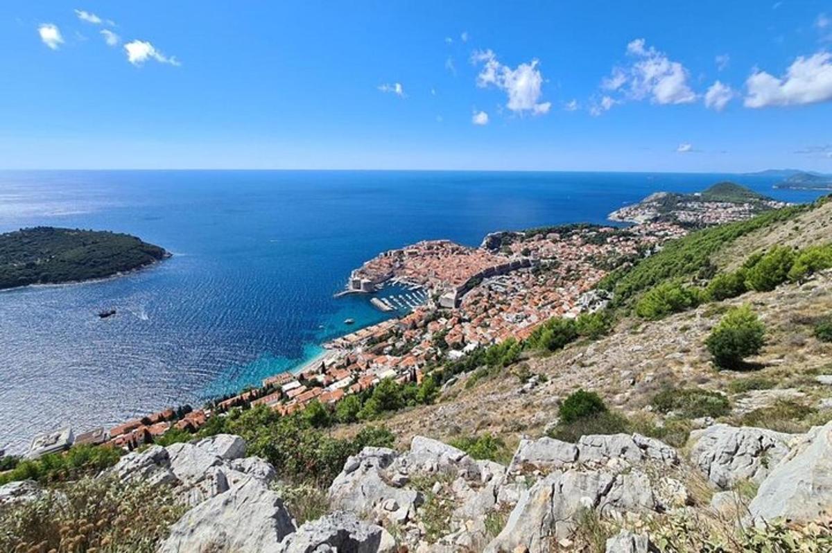 a view of a town on a hill with the ocean