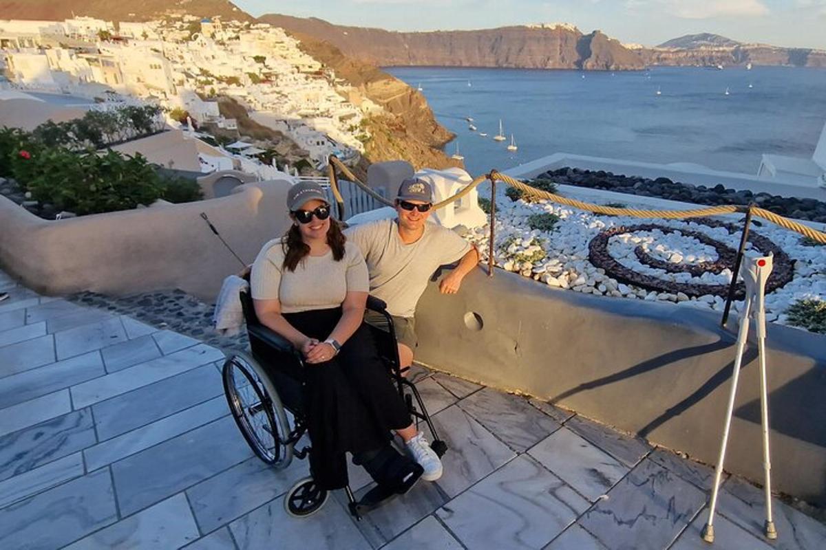 moški in ženska v invalidskem vozičku sedita na robu pobočja z oceanom