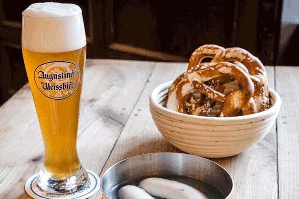 un bicchiere di birra accanto a una ciotola di pretzel