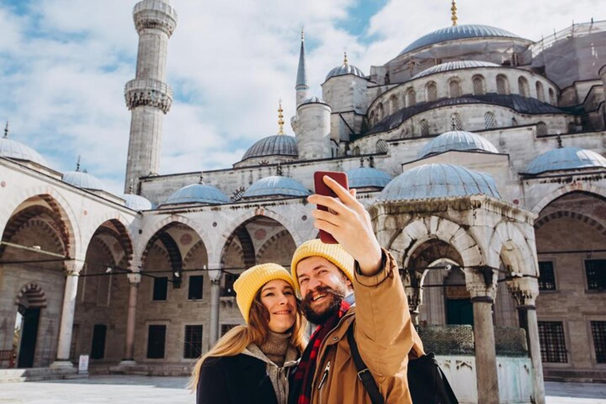 muž a žena fotografují mešitu