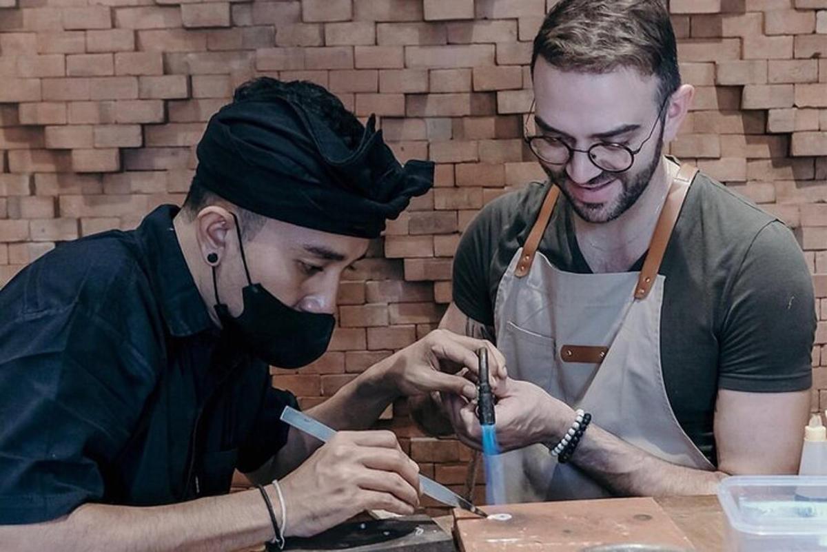 two men are working on a piece of wood