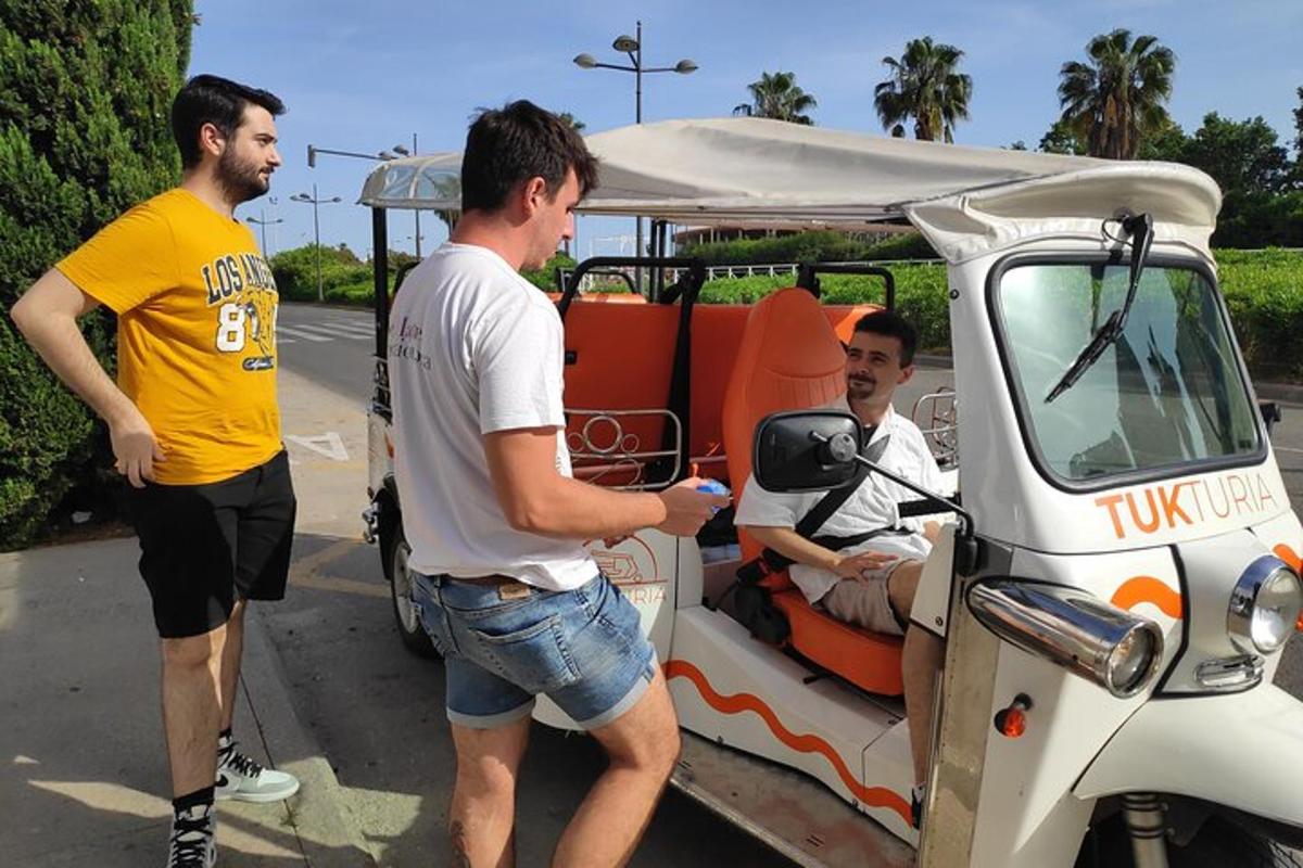 egy csoport férfi áll egy golfkocsi mellett