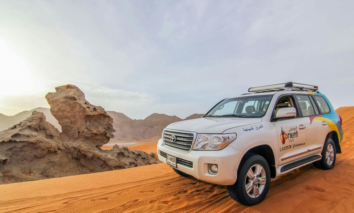 a white truck driving in the desert