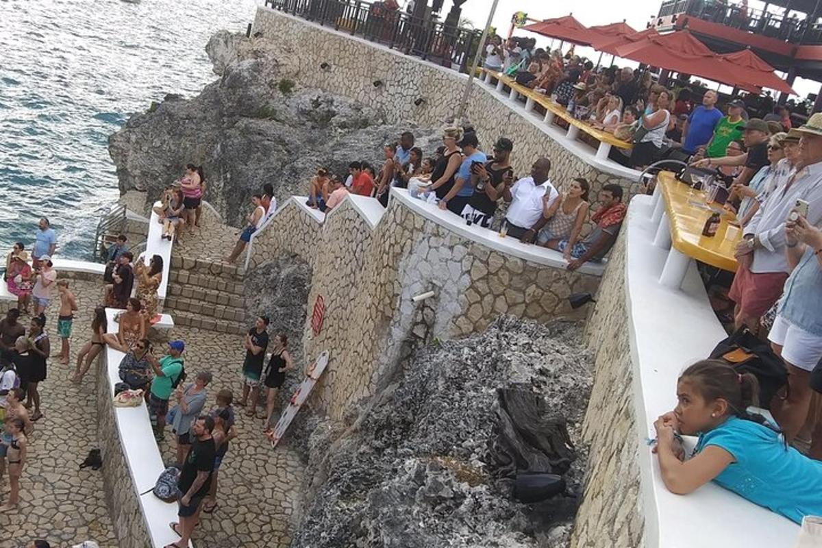 a crowd of people standing on the stairs near the water