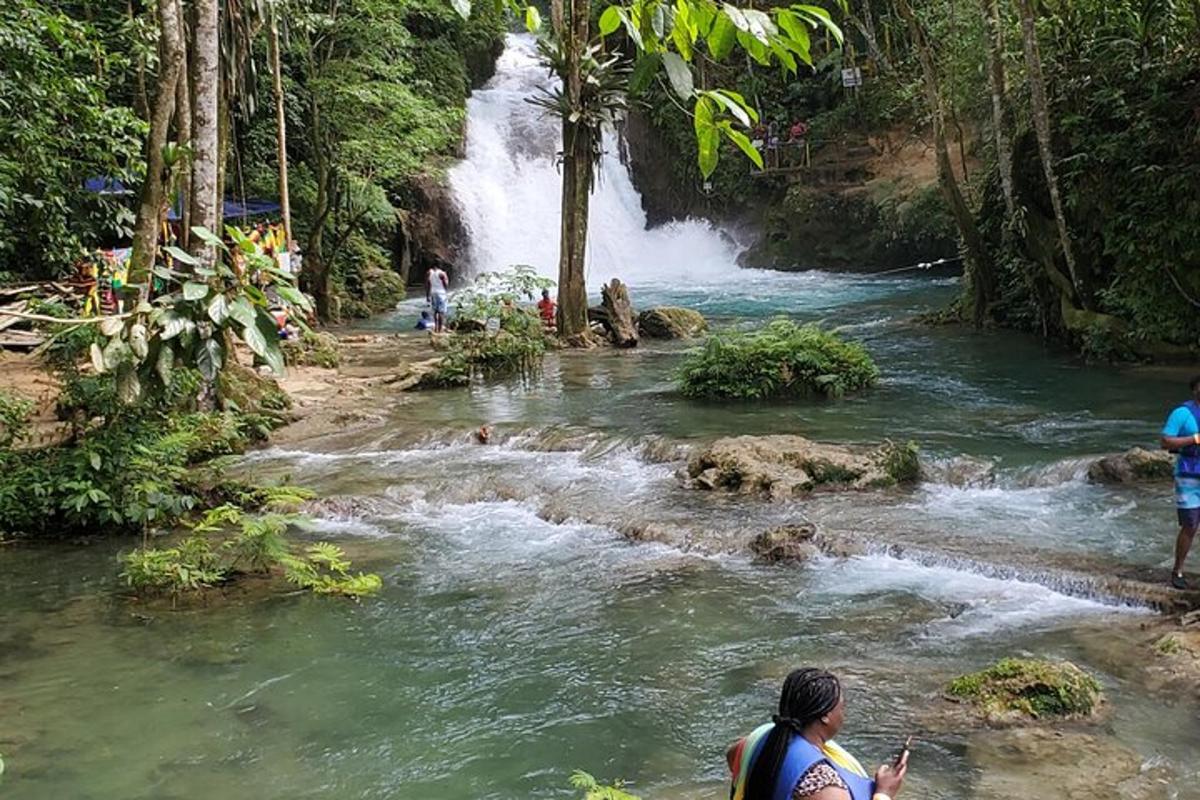 persone in piedi davanti a una cascata in un fiume