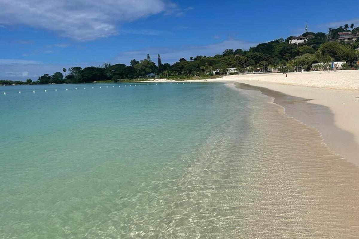 egy tiszta vízzel és lábnyomokkal a homokban ellátott strand