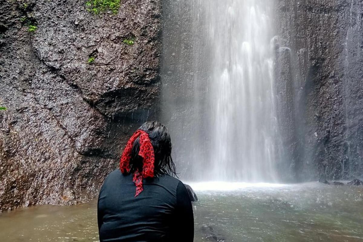 maður stendur fyrir framan foss