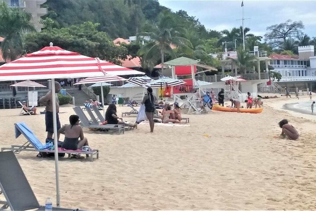 a group of people sitting on a beach with umbrellas