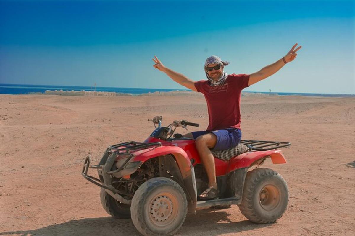 un home que condueix un quad al desert