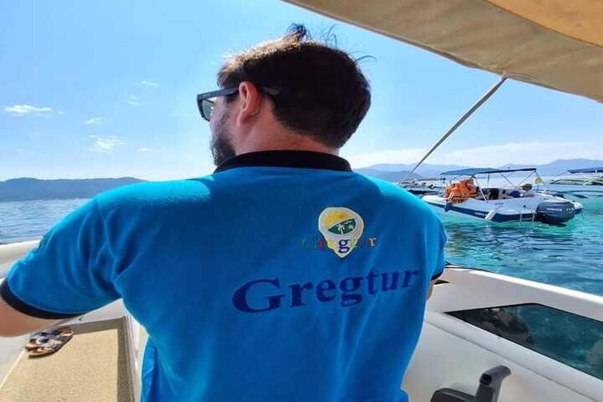 ein Mann in einem blauen Hemd auf einem Boot im Wasser