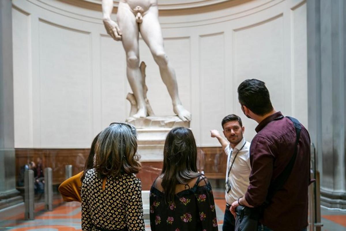un gruppo di persone che guarda una statua in un museo