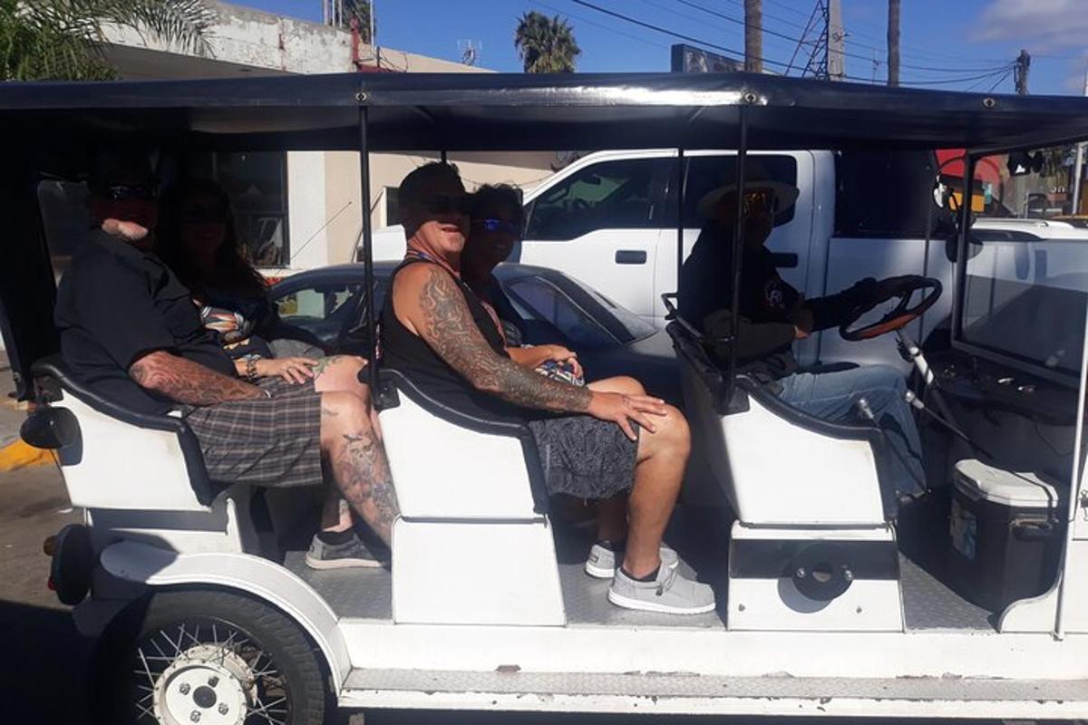 a group of people sitting in a golf cart