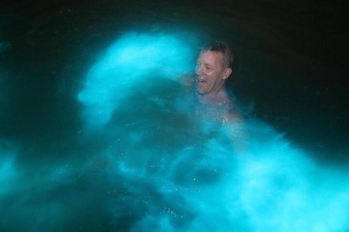 um homem em uma piscina com luzes azuis