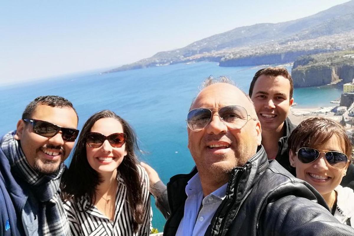 a group of people posing for a picture in front of the ocean
