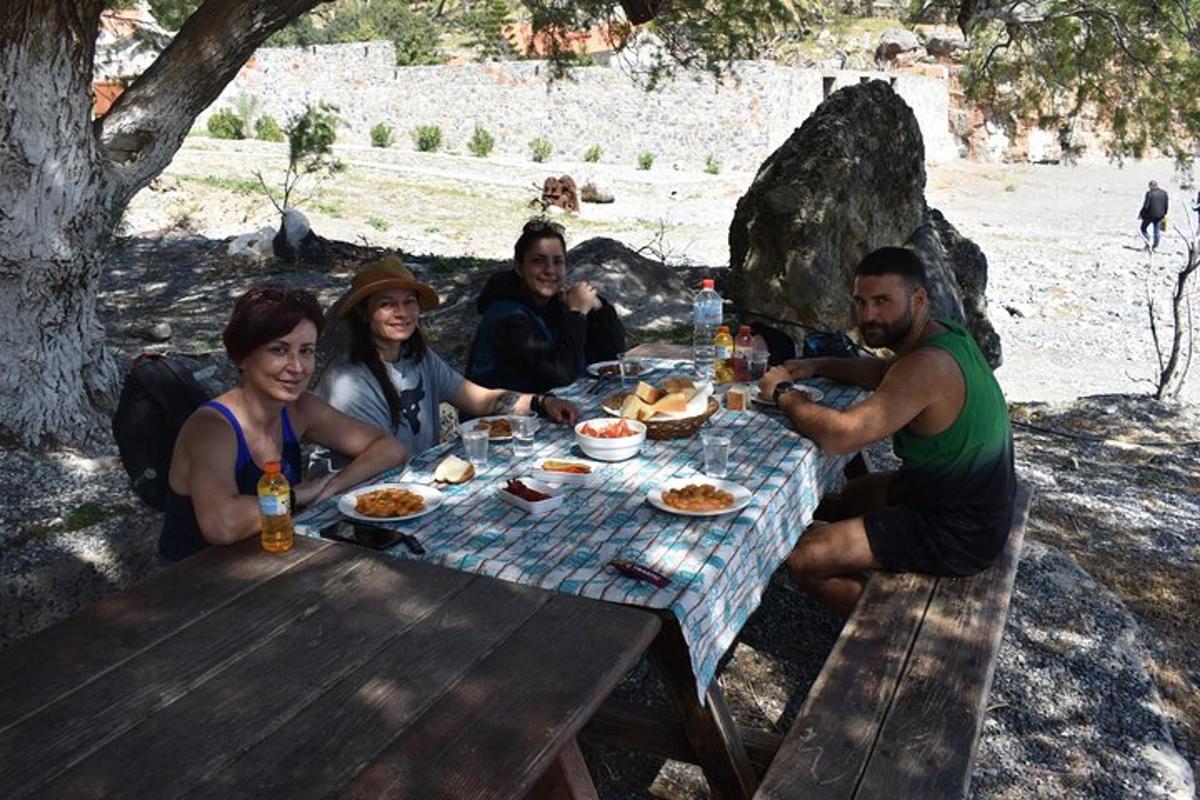 μια ομάδα ανθρώπων που κάθονται γύρω από ένα τραπέζι πικνίκ