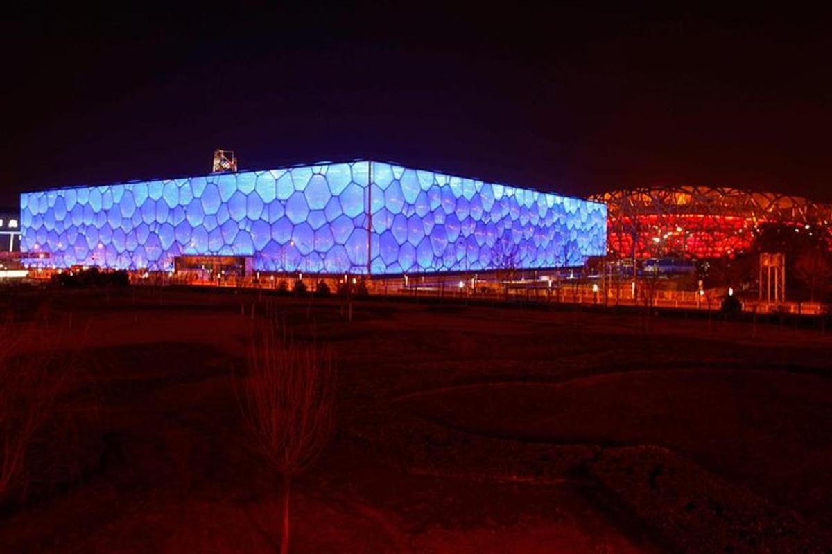 Un gran edificio azul está iluminado por la noche.