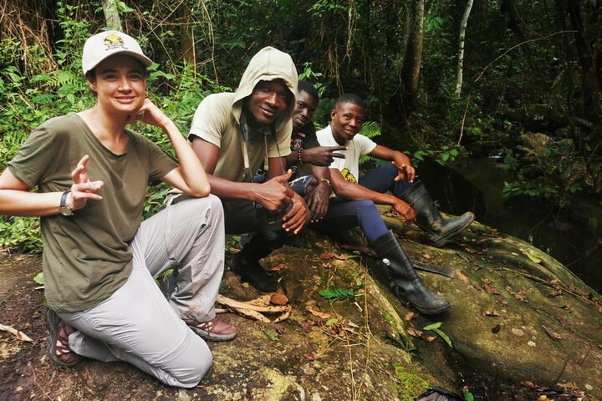 Un grupo de hombres sentados en una roca en el bosque.