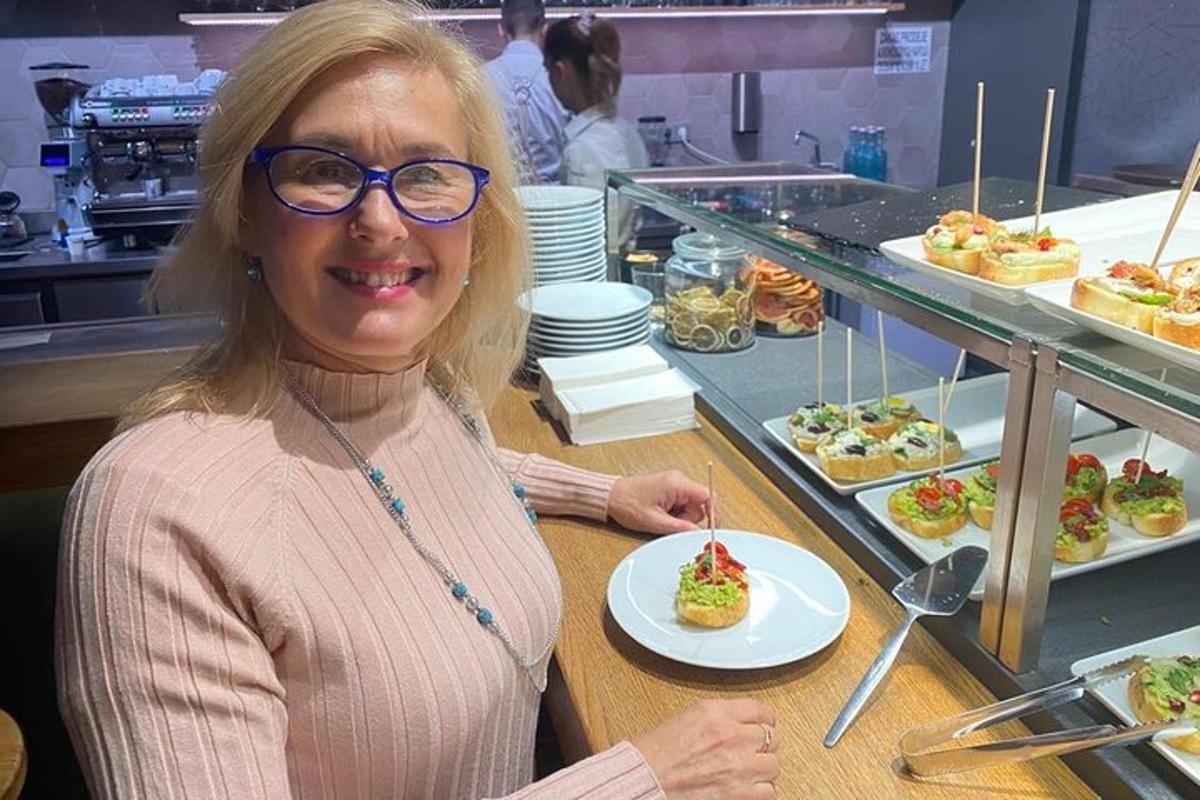 Una mujer sentada en un mostrador con un plato de comida.