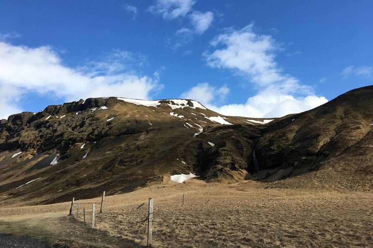 ein Berg mit einem Zaun davor