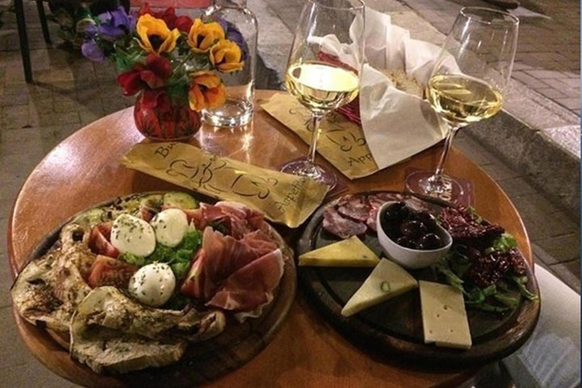 una mesa con dos platos de comida y dos copas de vino