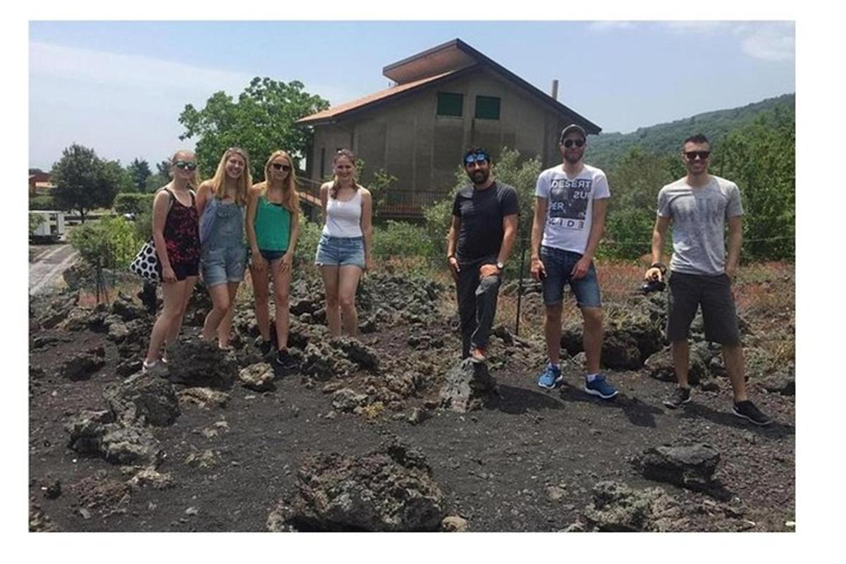 skupina ljudi, ki stojijo pred hišo