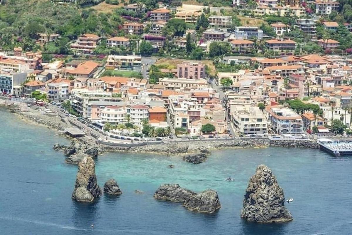 an aerial view of a city with rocks in the water