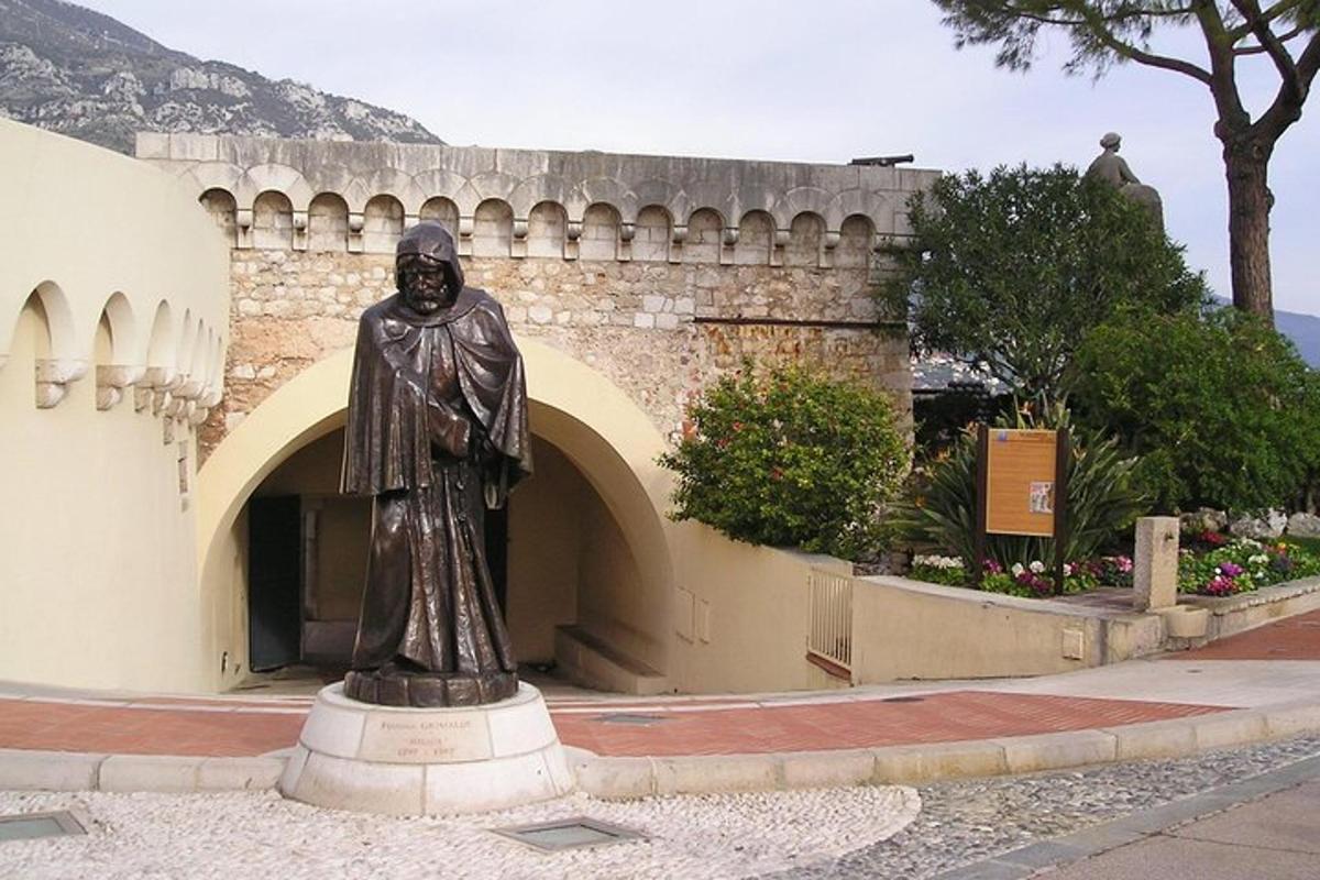 ένα άγαλμα ενός άνδρα που στέκεται μπροστά από ένα κτίριο