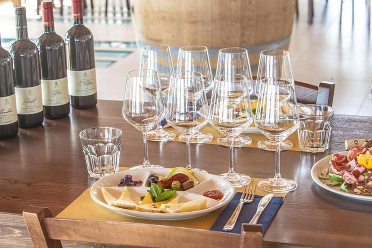 uma mesa com taças de vinho e um prato de comida