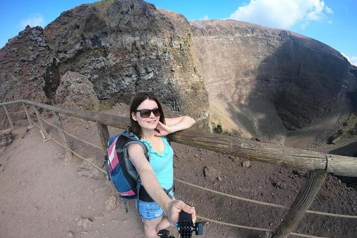 isang babaeng may hawak na camera sa tuktok ng bundok