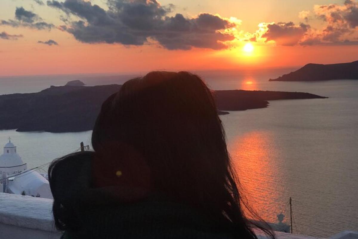 μια γυναίκα φωτογραφίζει το ηλιοβασίλεμα
