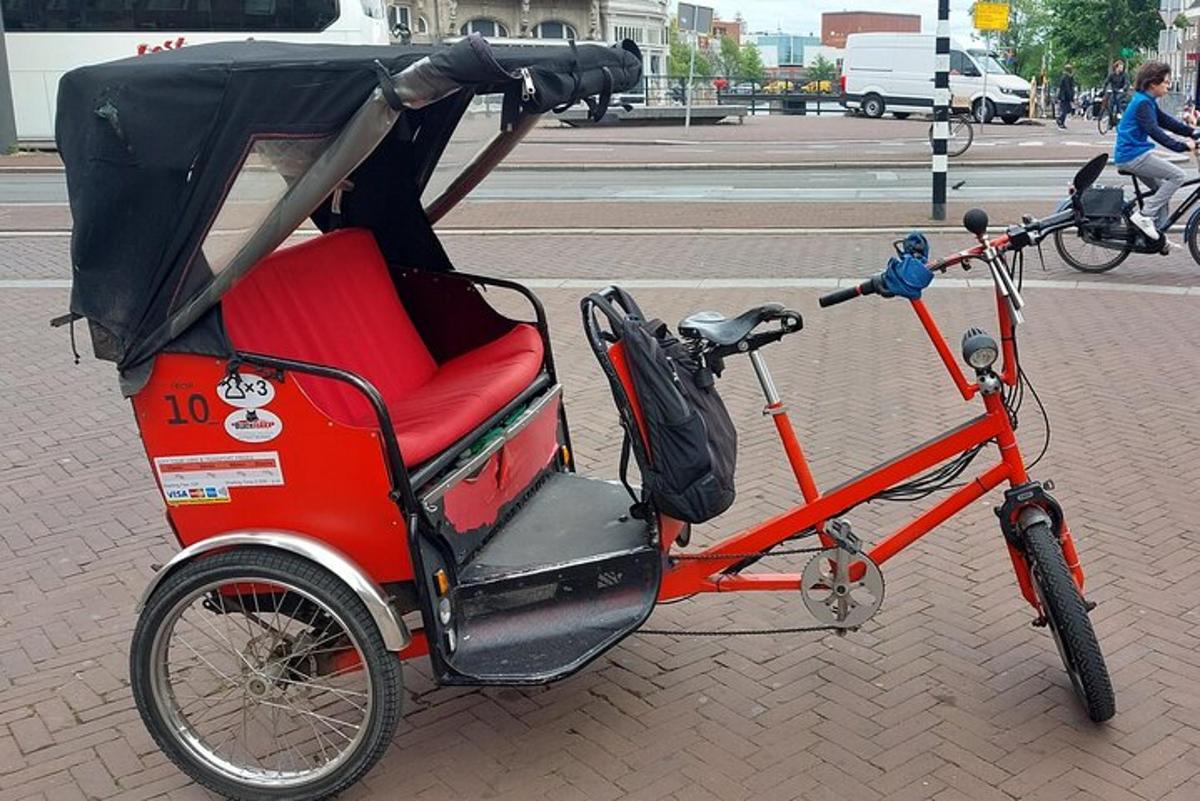 una bicicleta roja estacionada al costado de una calle