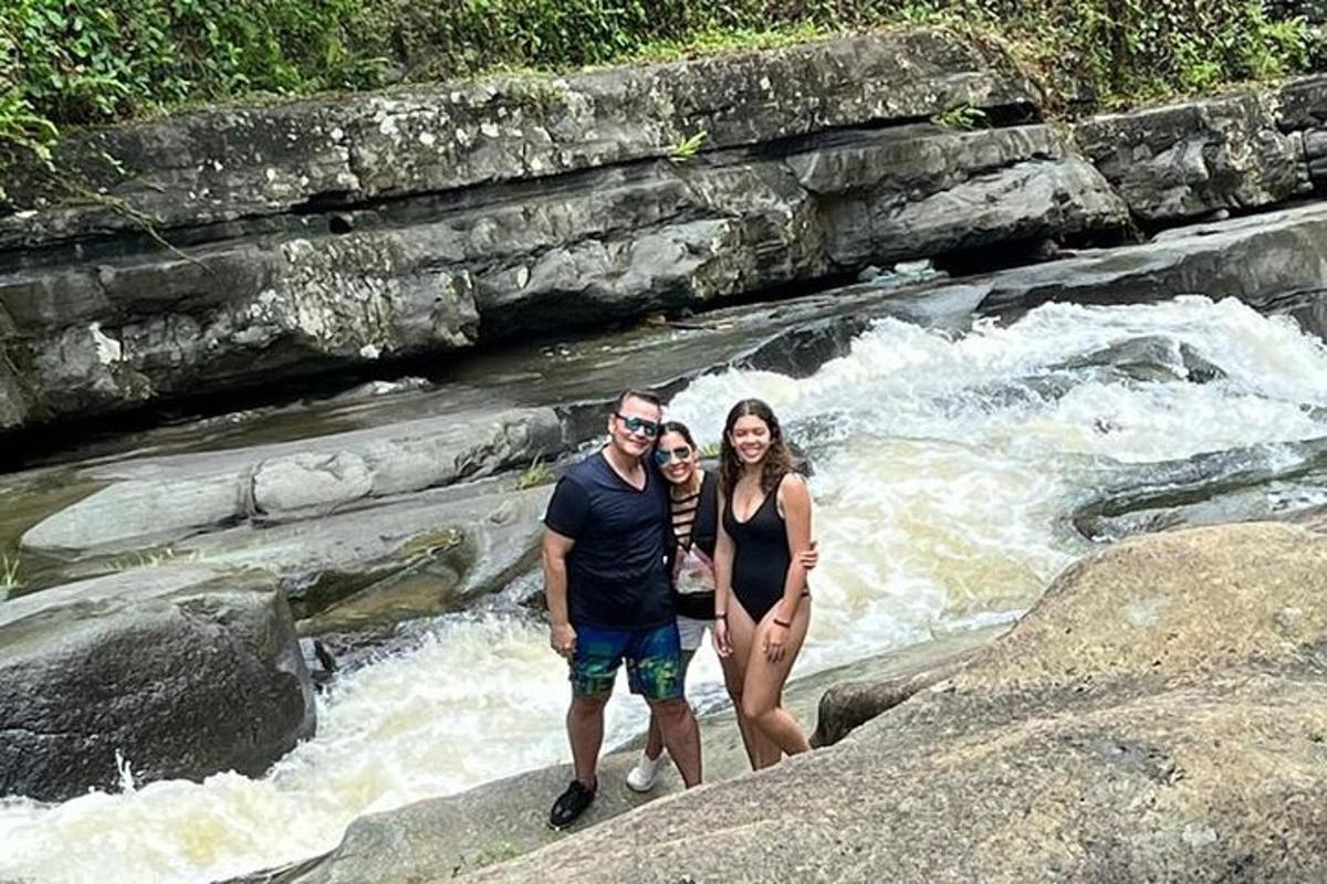 a man and a woman standing on rocks in a river