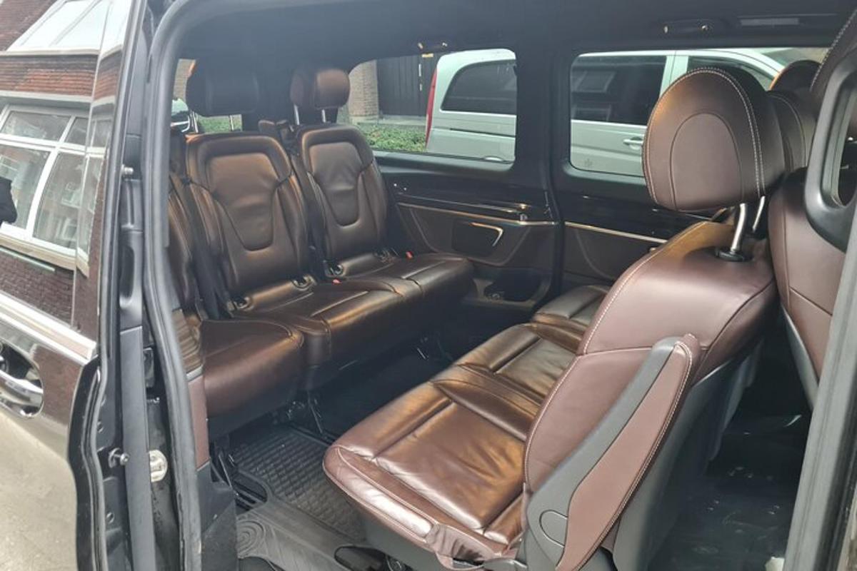 Un asiento trasero abierto de un coche con asientos marrones.