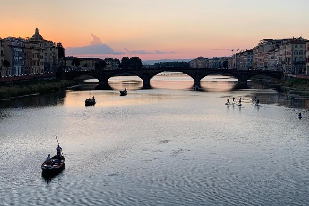 um rio com barcos na água com uma ponte