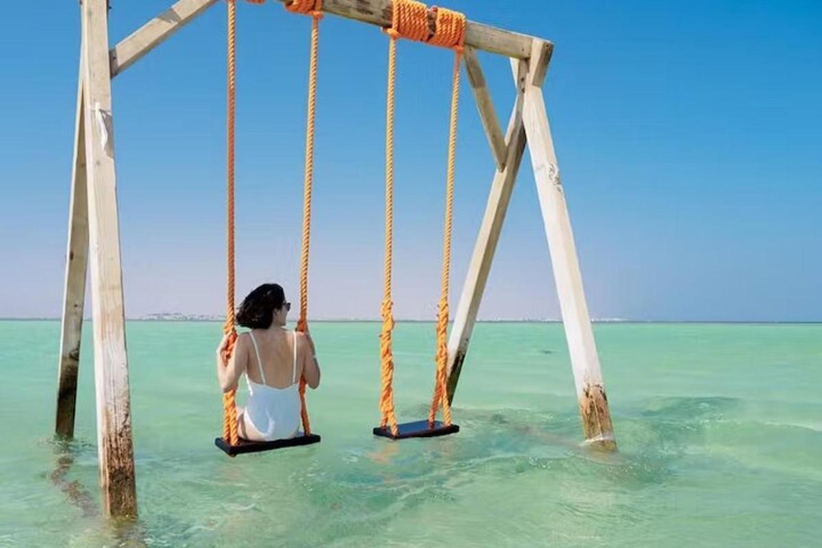 海のブランコに座っている女性