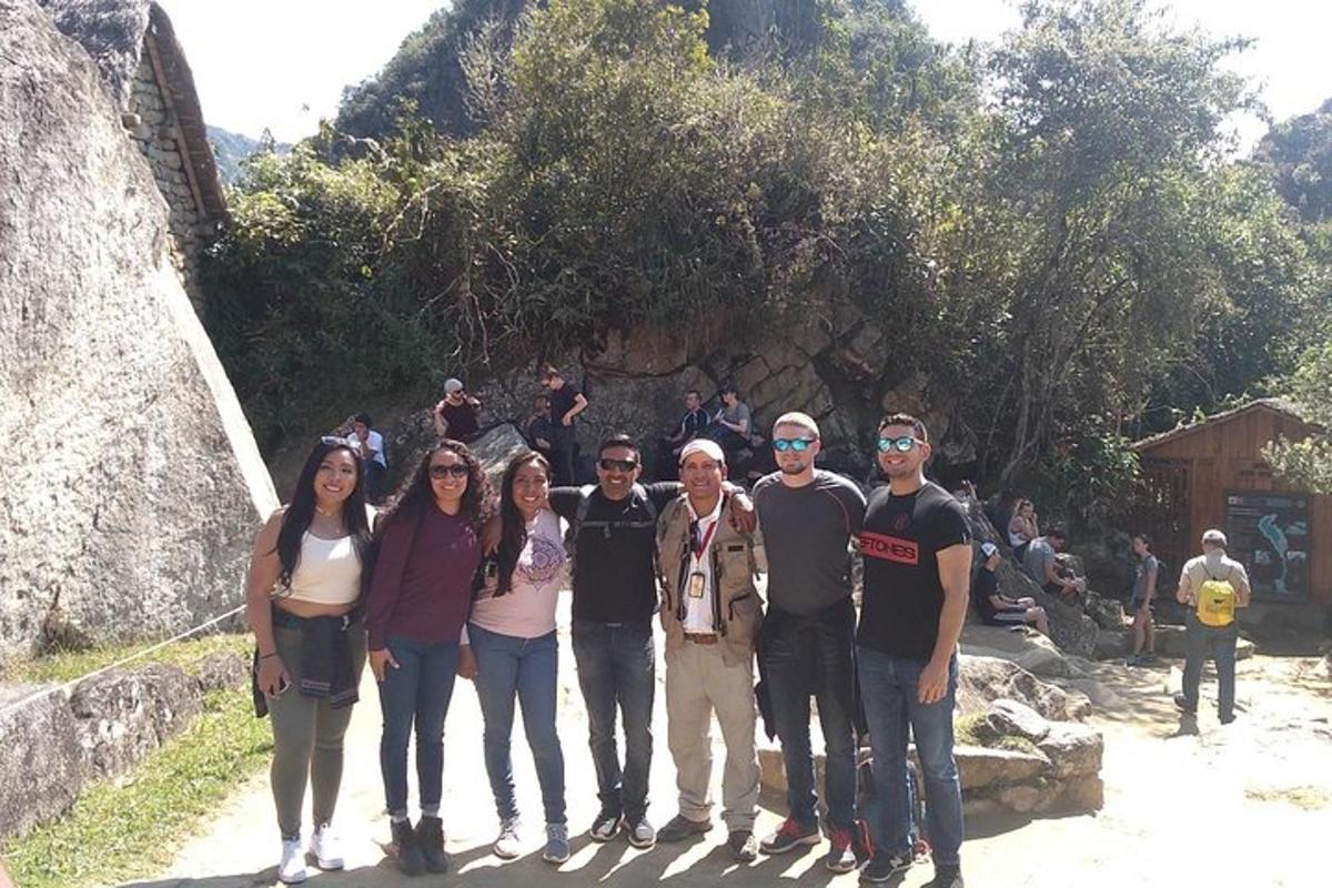 um grupo de pessoas em pé em frente a uma cachoeira