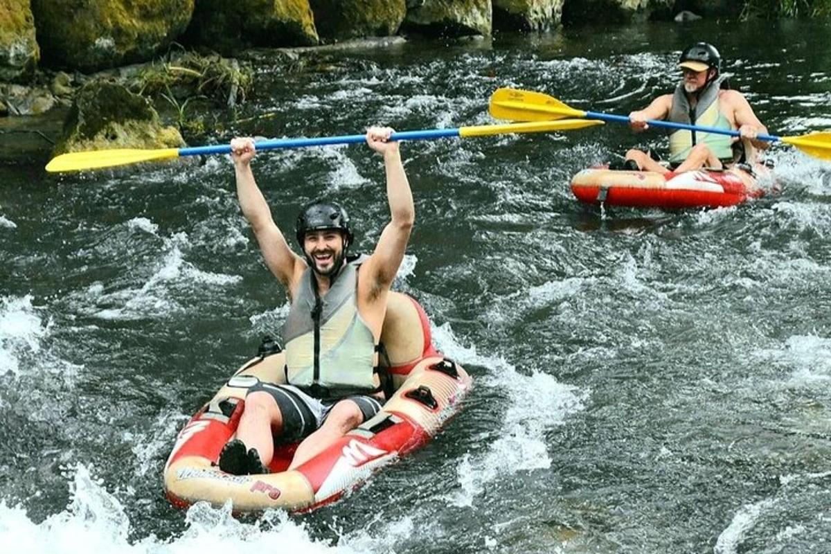 Dva muži sjíždějí řeku na raftu