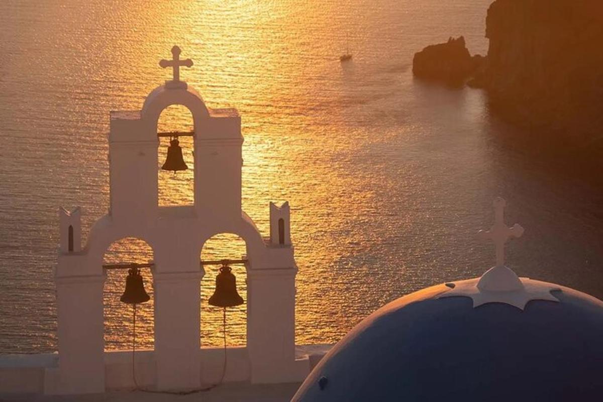 μια εκκλησία με σταυρό στην κορυφή της δίπλα στο νερό