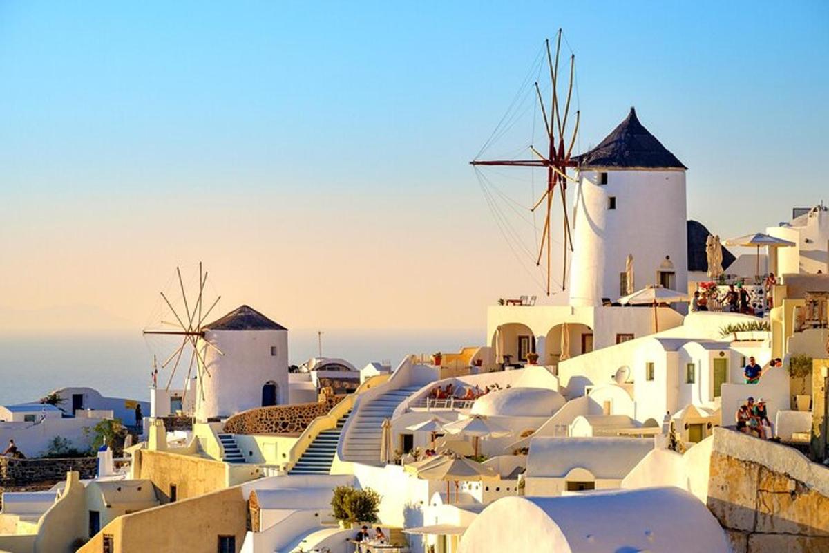 μια ομάδα από λευκά κτίρια και ανεμόμυλους σε έναν λόφο