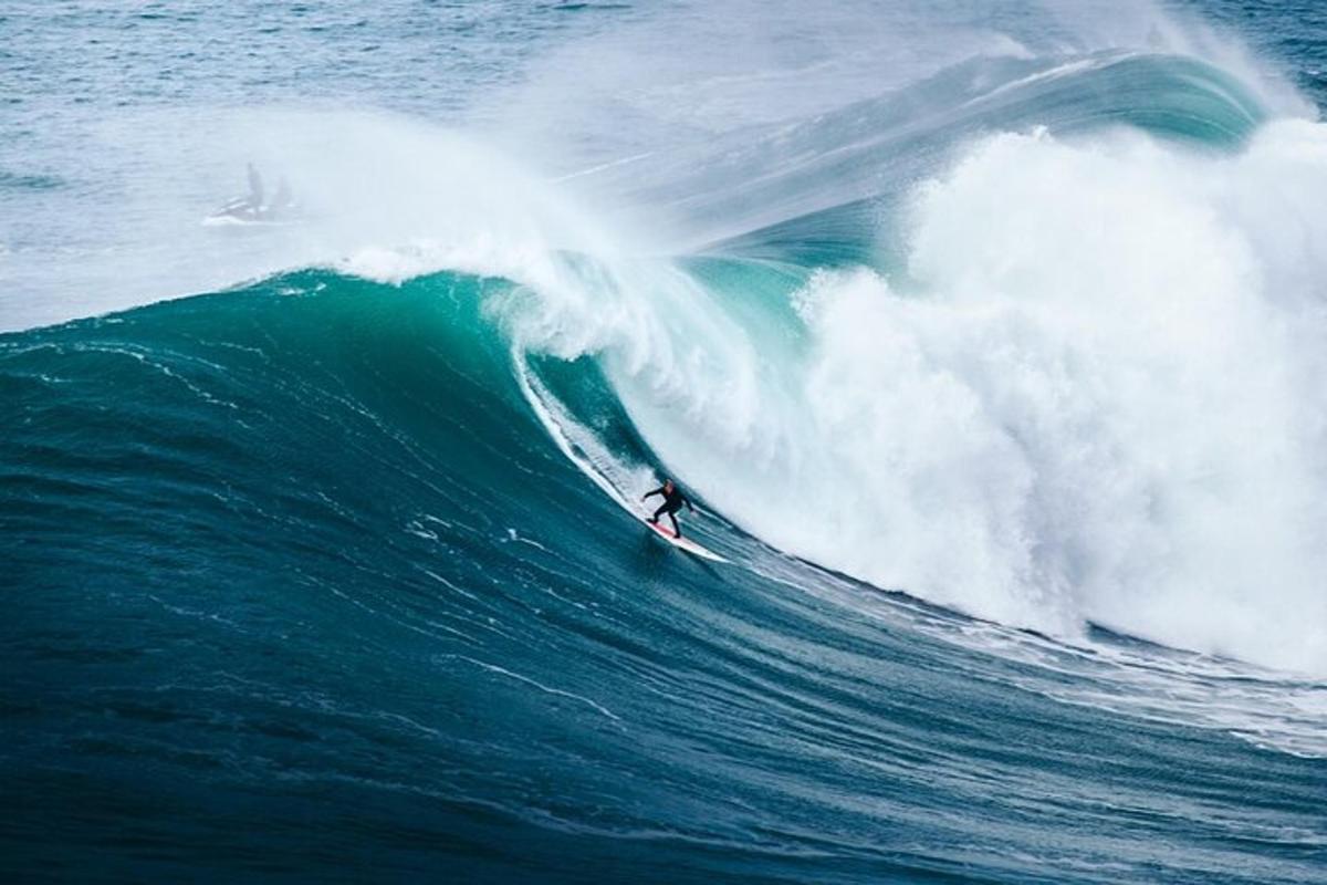 en mann som rir på en bølge på et surfebrett i havet