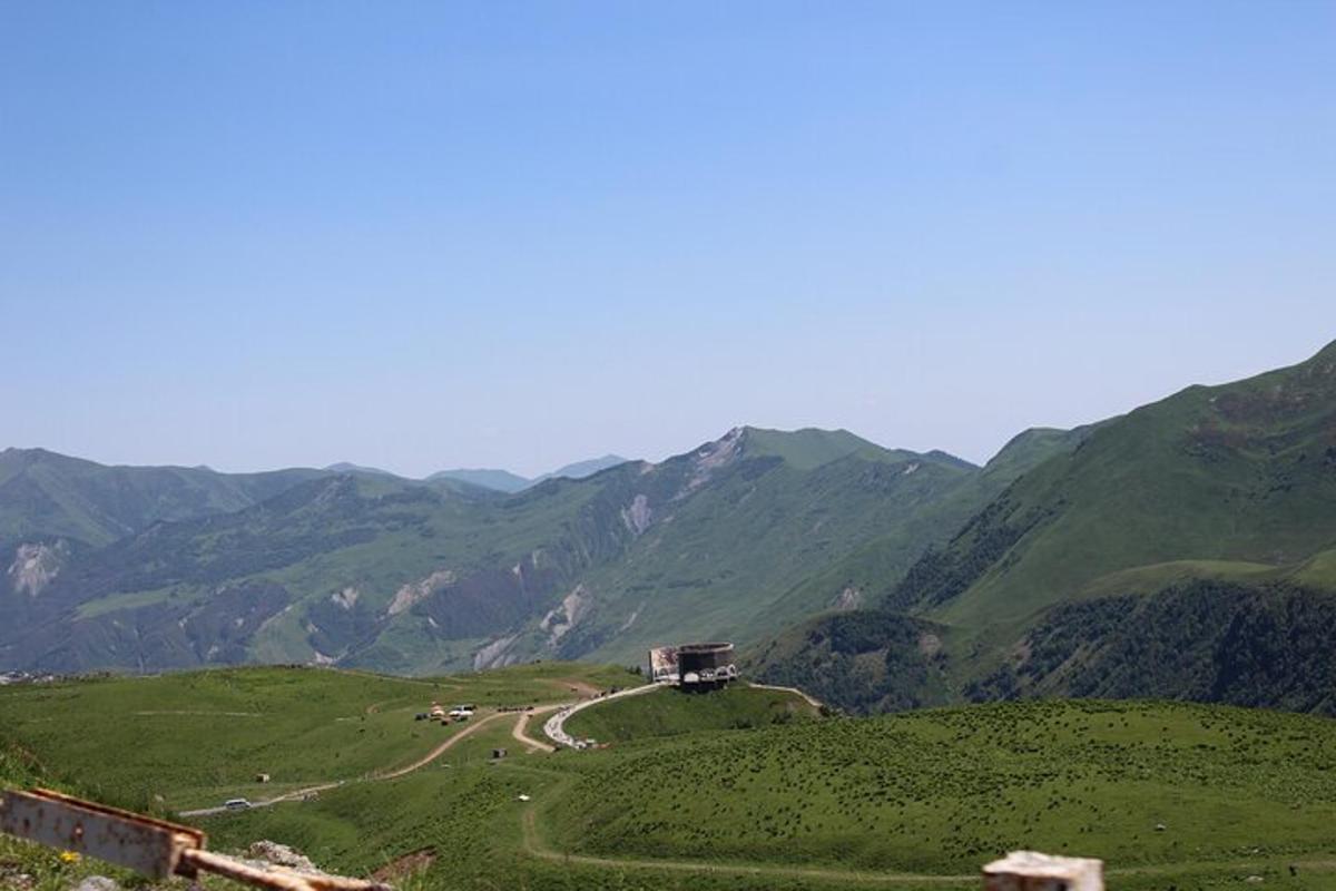 vijugasta cesta na zelenem hribu z gorami